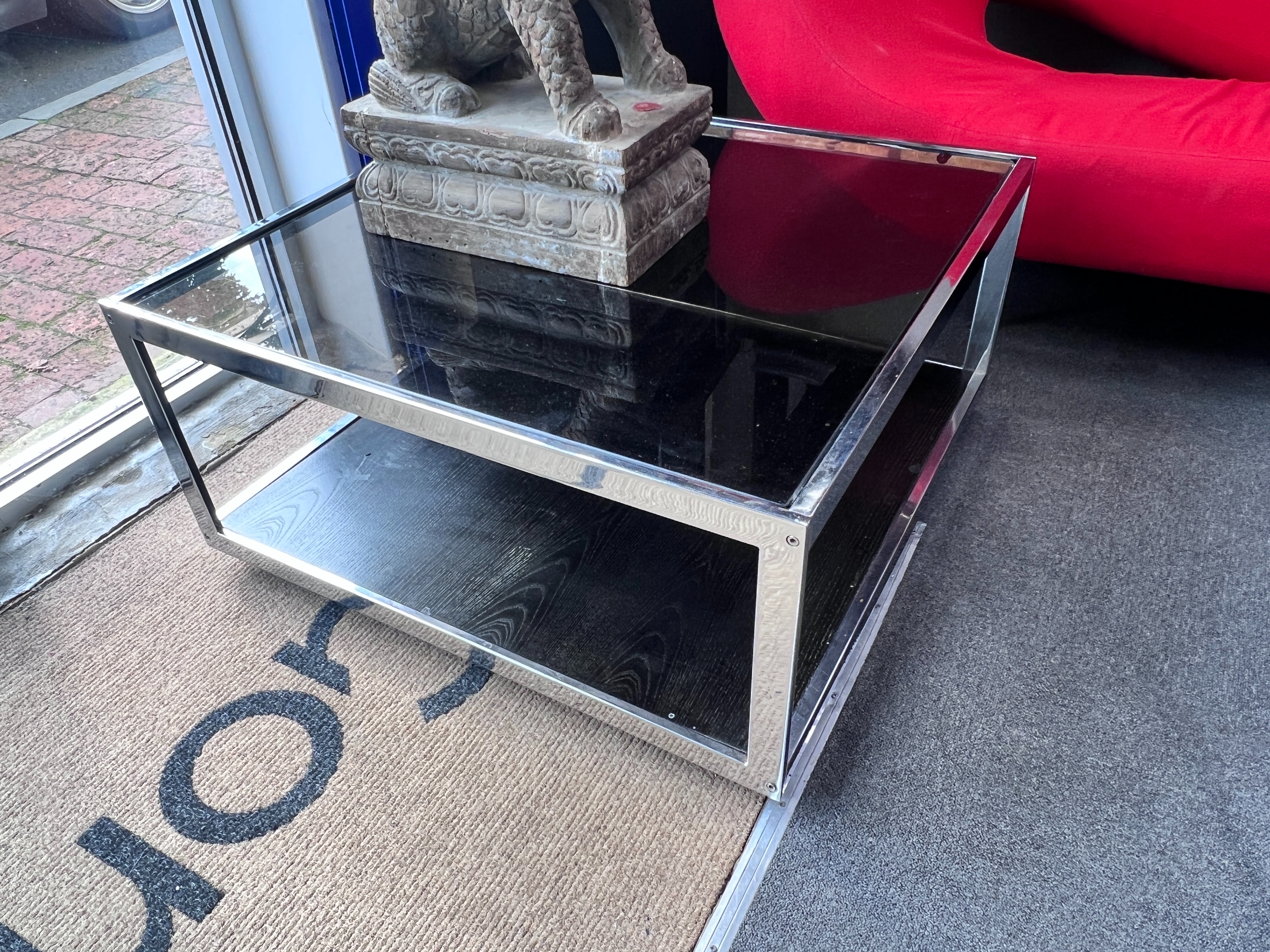 A pair of chrome and smoked glass Merrow associates style two tier occasional tables, width 84cm, depth 83cm, height 42cm